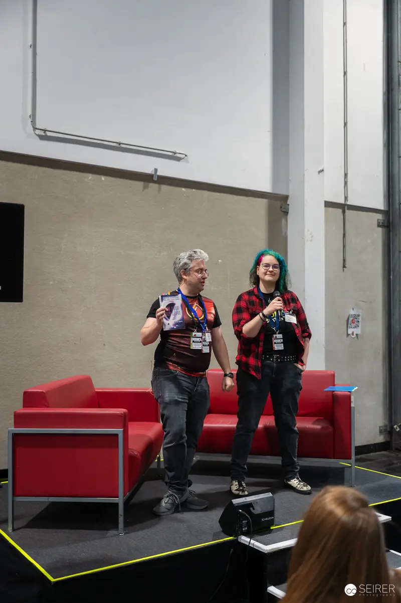 Two Speakers on Stage at Vienna ComicCon 2024 Conference Panel