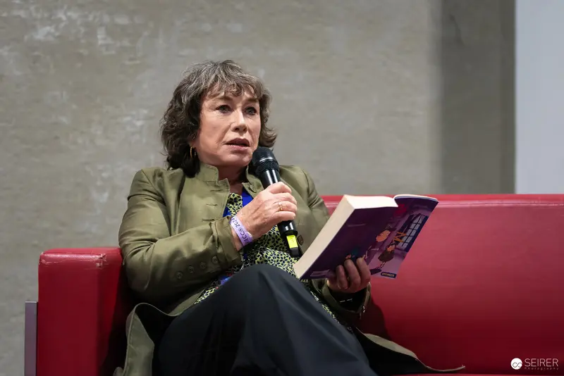 Author Reading Book on Red Stage at Literary Event
