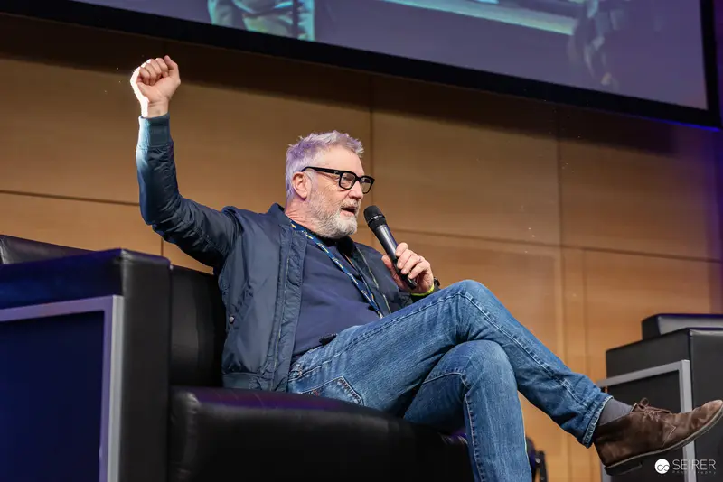 Energetic Speaker Raises Fist During Tech Conference Presentation