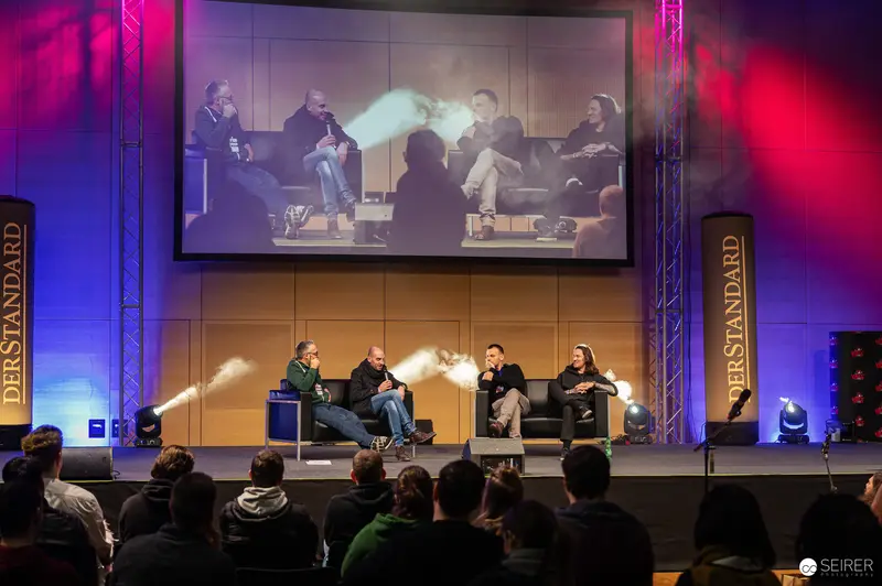 Panel Discussion at PerStandard Event Featuring Multiple Speakers on Stage