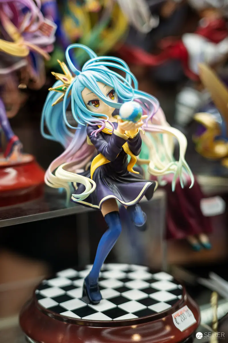 Anime Figurine of Blue-Haired Character on Checkered Display Base