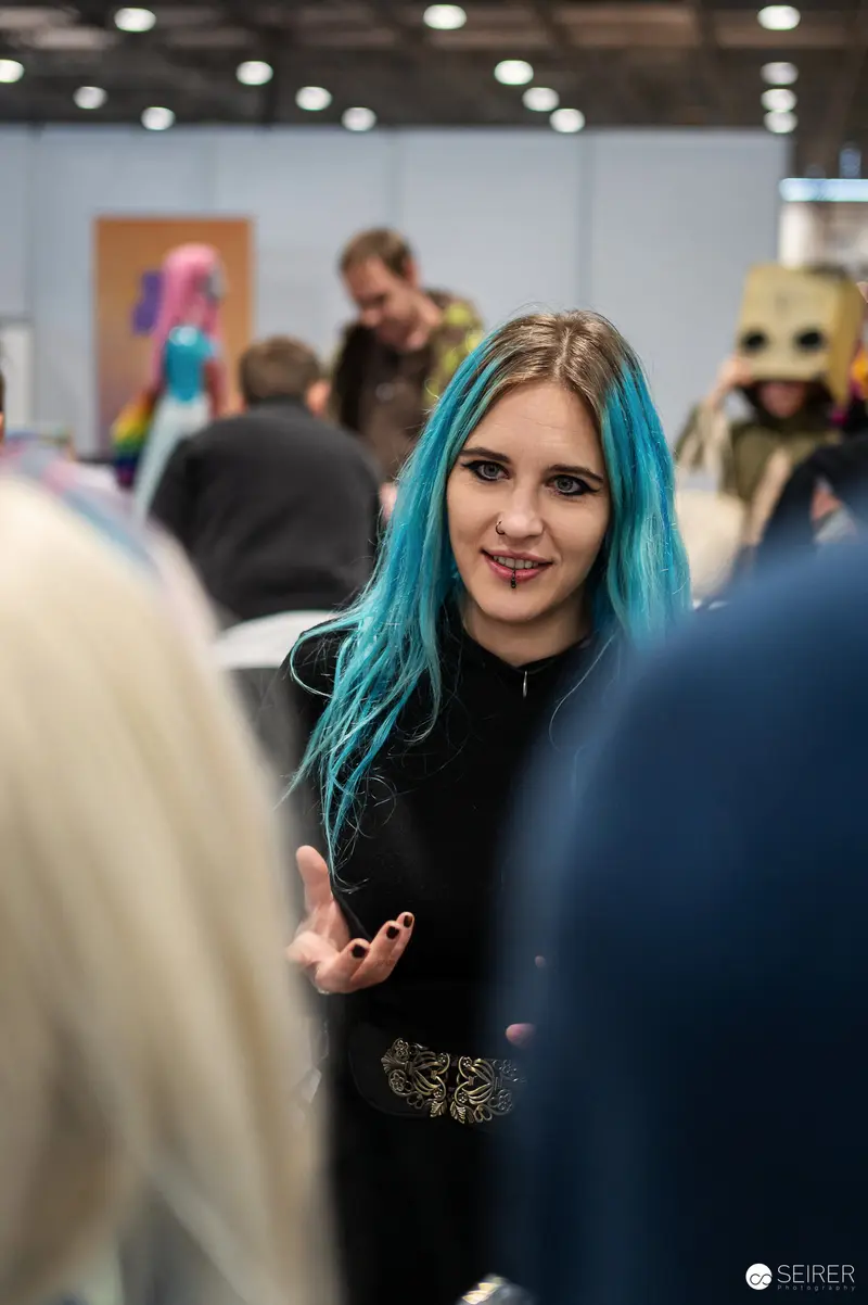 Blue-Haired Attendee Interacts at Vienna ComicCon 2024