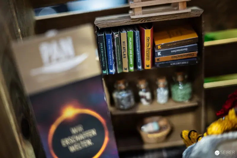 Vintage Book Collection and Small Decorative Bottles on Wooden Shelf