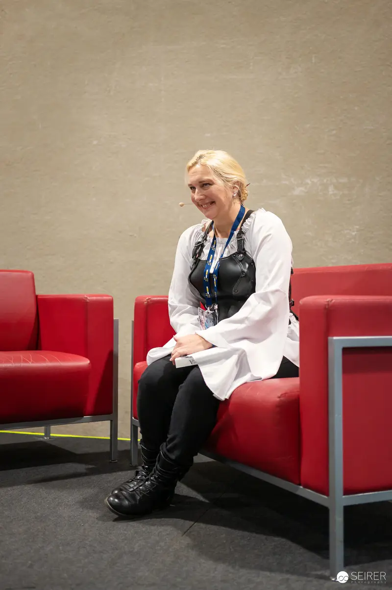 Relaxed Attendee at Vienna ComicCon 2024 in Red Seating Area