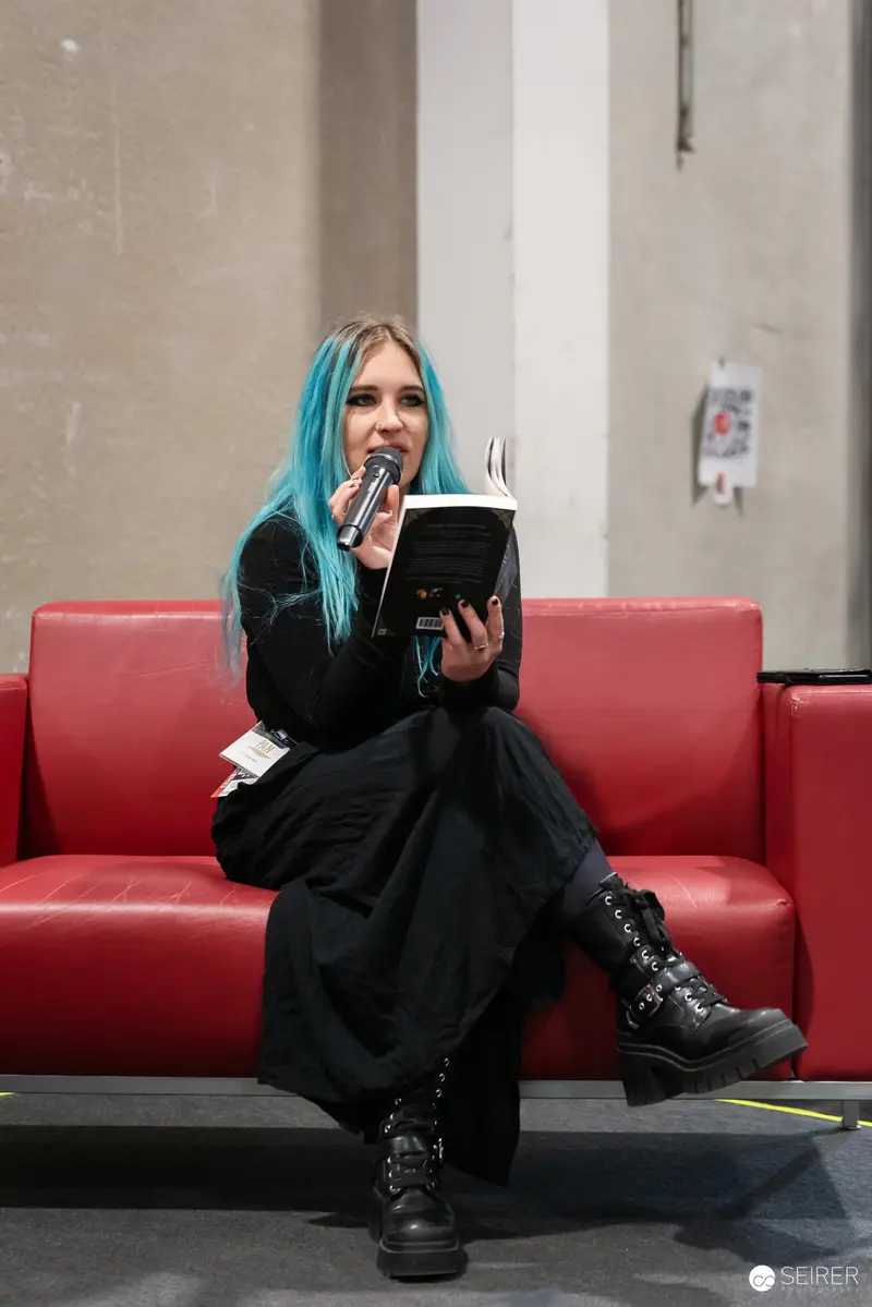 Blue-Haired Cosplayer Reading at Vienna ComicCon 2024