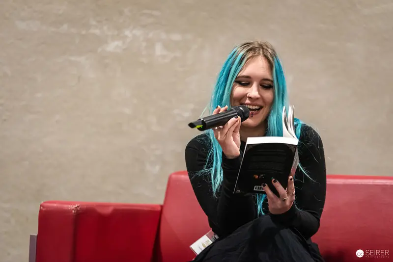 Blue-Haired Fan Reads Book at Vienna ComicCon 2024