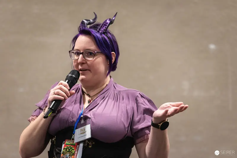Purple-Haired Speaker at Vienna ComicCon 2024 in Cosplay Presentation
