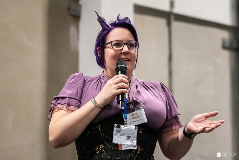 Purple-Haired Speaker at Vienna ComicCon 2024 in Distinctive Cosplay Outfit