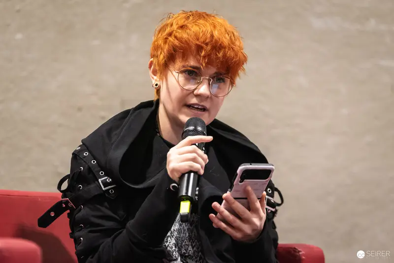 Vibrant-Haired Speaker with Microphone at Vienna ComicCon 2024