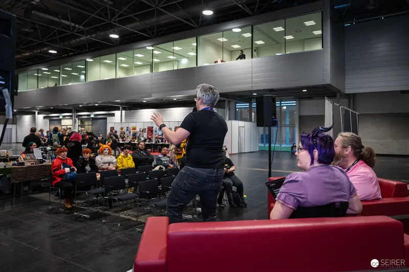 Speaker Addressing Audience at Vienna ComicCon 2024 Convention Hall