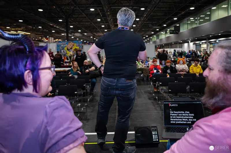 Speaker Addressing Audience at Vienna ComicCon 2024 Convention Hall
