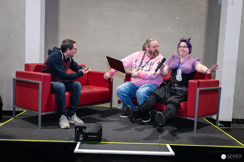 VIECC 2024: Cosplay Panelists Relaxing on Red Sofas at Vienna Comic Convention
