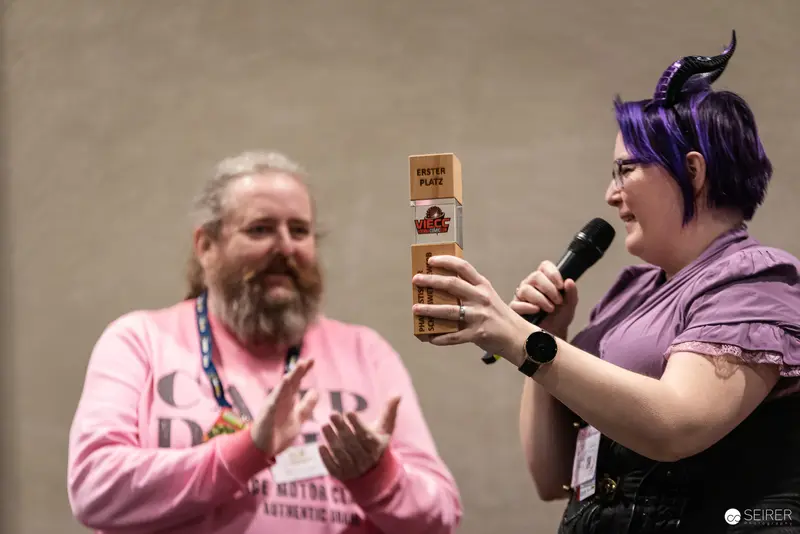 Purple-Haired Speaker Presenting Award at Vienna ComicCon 2024