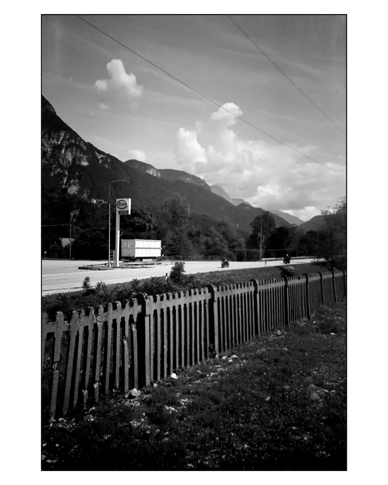 Motorcyclists pass an Esso station on the Alpine road between Villach and Grado, 2024