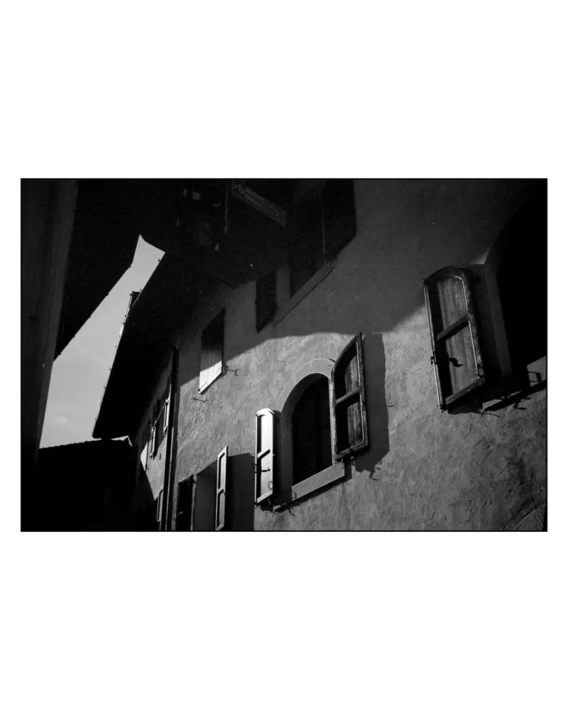 Arched shuttered windows on a narrow alley facade, Grado, Italy, 2024
