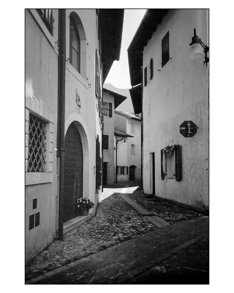 Cobbled alley with stone-arched doorway in Alpine village between Villach and Grado, 2024