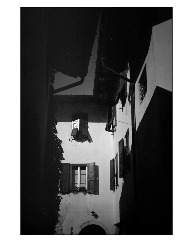 Sunlit Facade with Wooden Shutters in a Narrow Alley, Grado, Italy