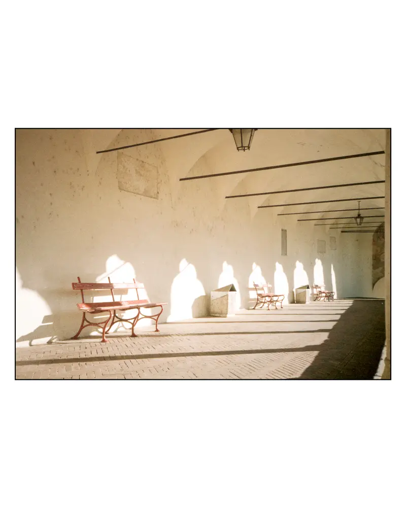 Red Benches in Sunlit Vaulted Arcade, Grado, Italy