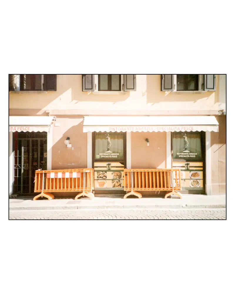 Ristorante Abbazia seafood restaurant closed behind orange barriers, Grado, Italy