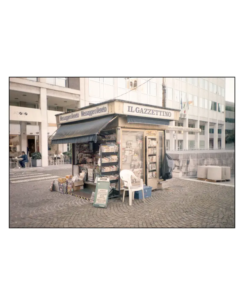 Il Gazzettino and Messaggero Veneto newsstand kiosk on cobbled square, Grado, Italy