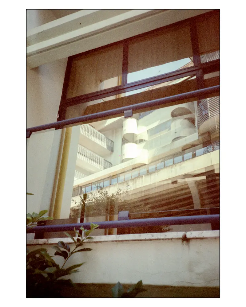 Modernist apartment balconies reflected in glass, Grado seafront architecture, Italy