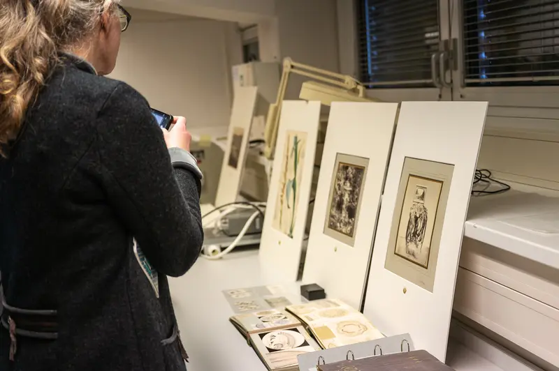 NHM Wien Curator Examining Archival Photographic Prints in Research Space