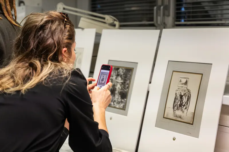 Curator Examining Archival Photograph at Naturhistorisches Museum Wien Photo Exhibition