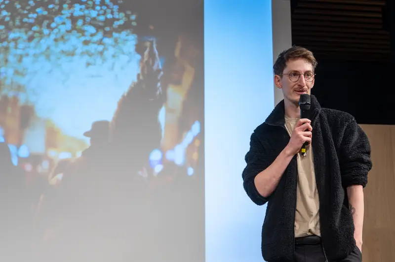 Technology Conference Speaker Presenting Keynote on Stage with Projection Screen