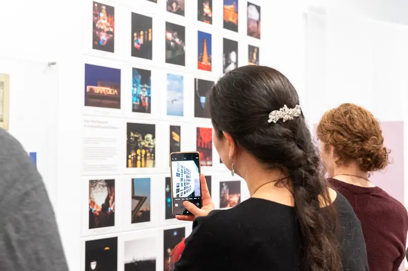 Art Gallery Visitor Photographing Exhibition Wall with Smartphone