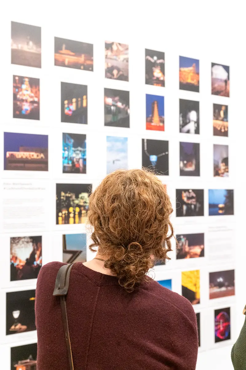 Gallery Visitor Examining Photographic Exhibition Wall of Diverse Images