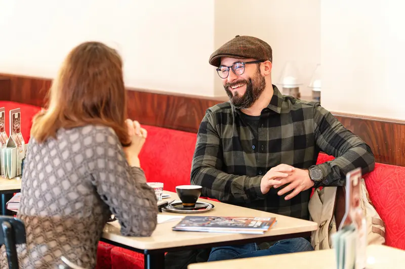 Falk Holzapfel and Janett Cernohuby Discuss in Cafe Museum, Vienna