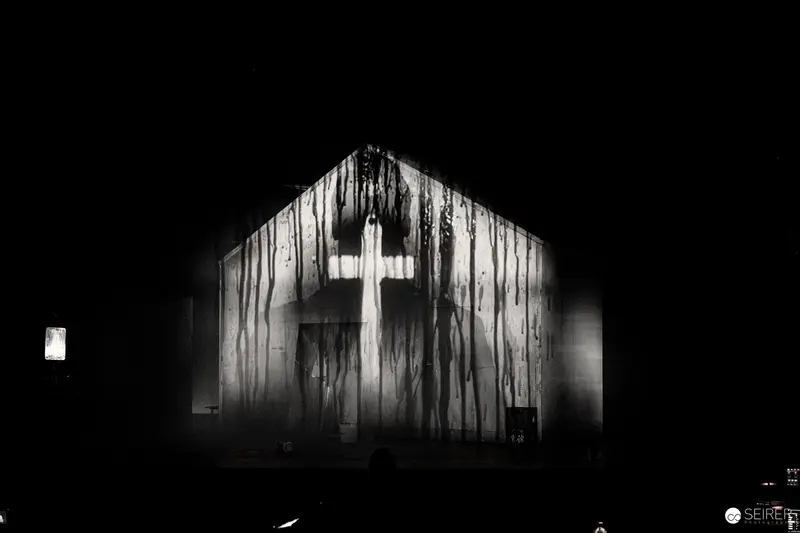 Dark Wooden Structure with Illuminated Cross in Stark Black and White