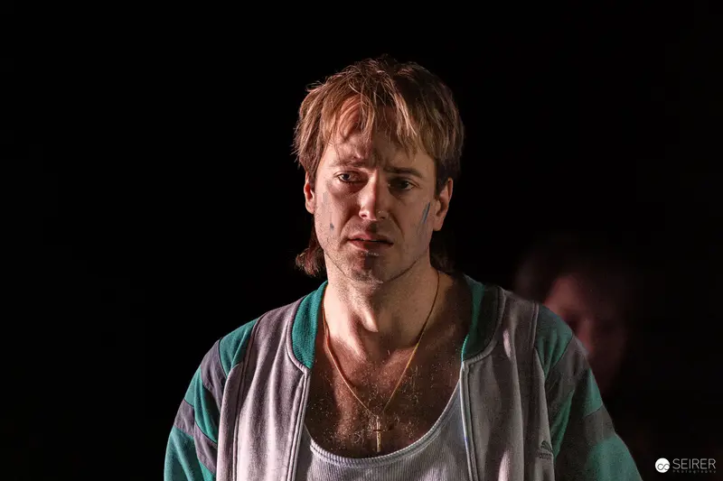 Actor in White and Teal During Theatrical Performance of "Azur oder die Farbe von Wasser"