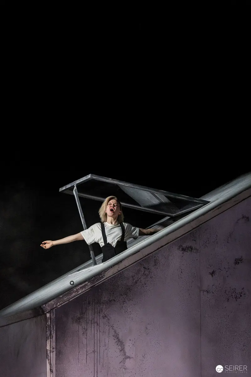 Actor Performing on Angled Stage in "Azur oder die Farbe von Wasser" Theater Production