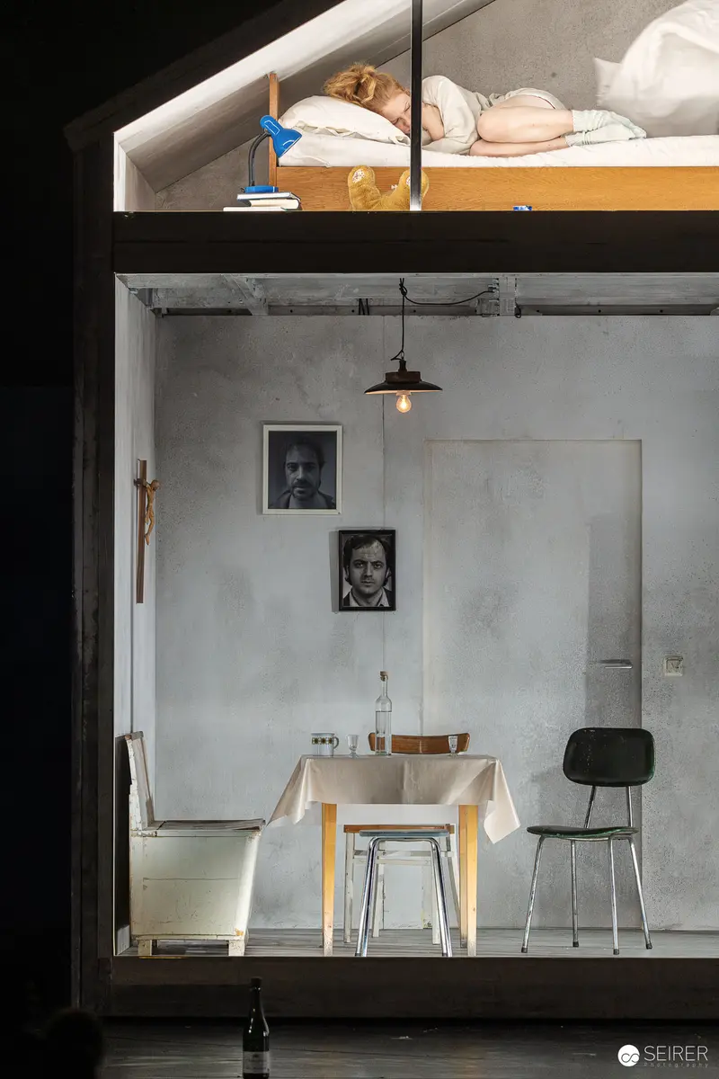 Intimate Theatrical Scene in Minimalist Setting with Portrait Photographs