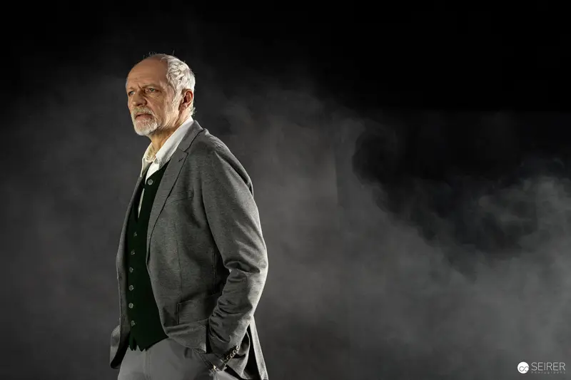 Senior Actor in Dark Dramatic Theatrical Pose During Stage Rehearsal