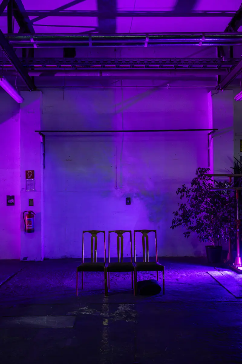 LINE RUNNER 2024: Purple-Lit Stage with Empty Chairs and Theatrical Setup