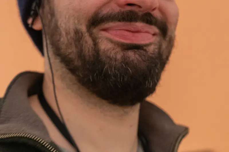Close-Up of Bearded Man in Leather Jacket Against Warm Background