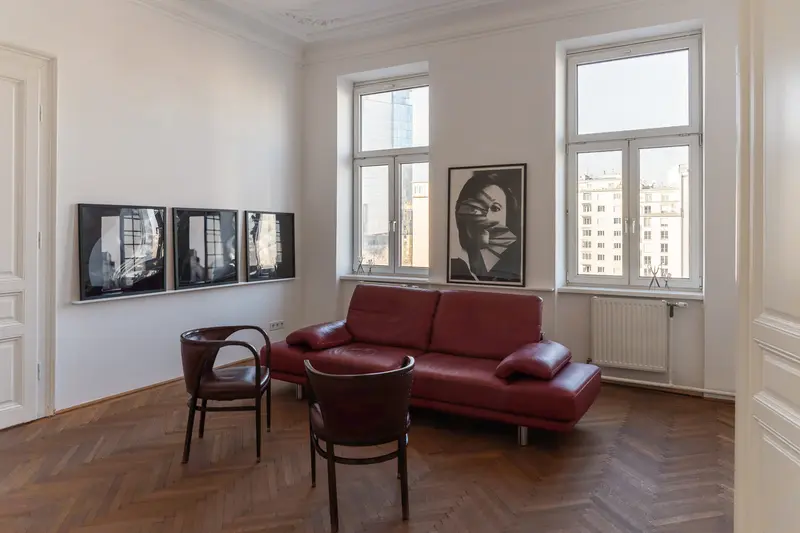 Contemporary Art Space with Red Sofa and Black and White Portraiture