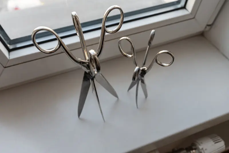 Two Vintage Scissors Positioned on White Windowsill