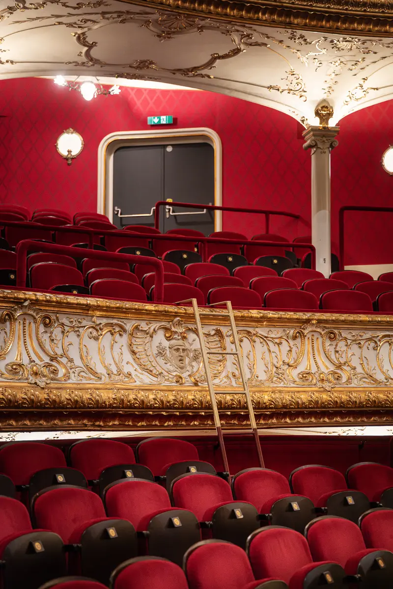Red-Upholstered Seats in Ornate Volkstheater Interior with Balcony