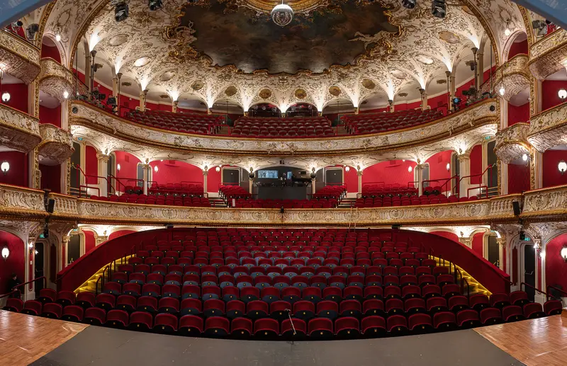 Ornate European Theater Interior with Red Seats and Elaborate Ceiling Decoration