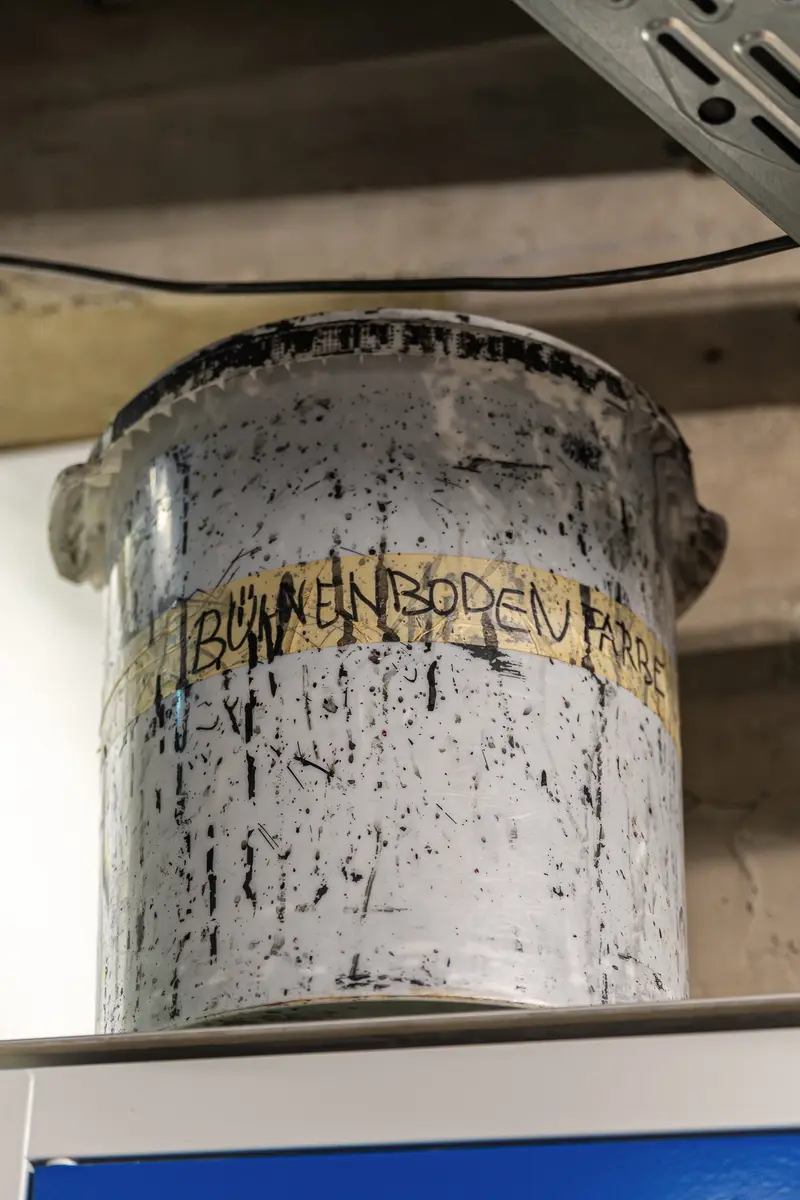 Weathered Storage Bucket with Faded Labeling in Industrial Setting