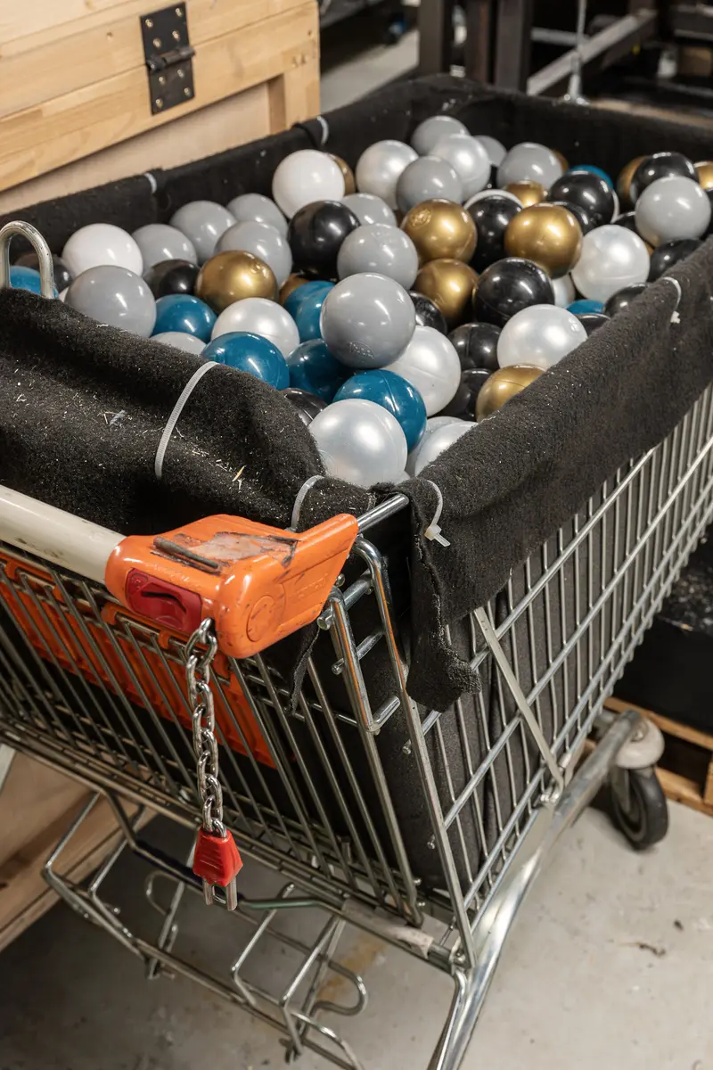 Shopping Cart Filled with Metallic and Gold Balloons in Workshop