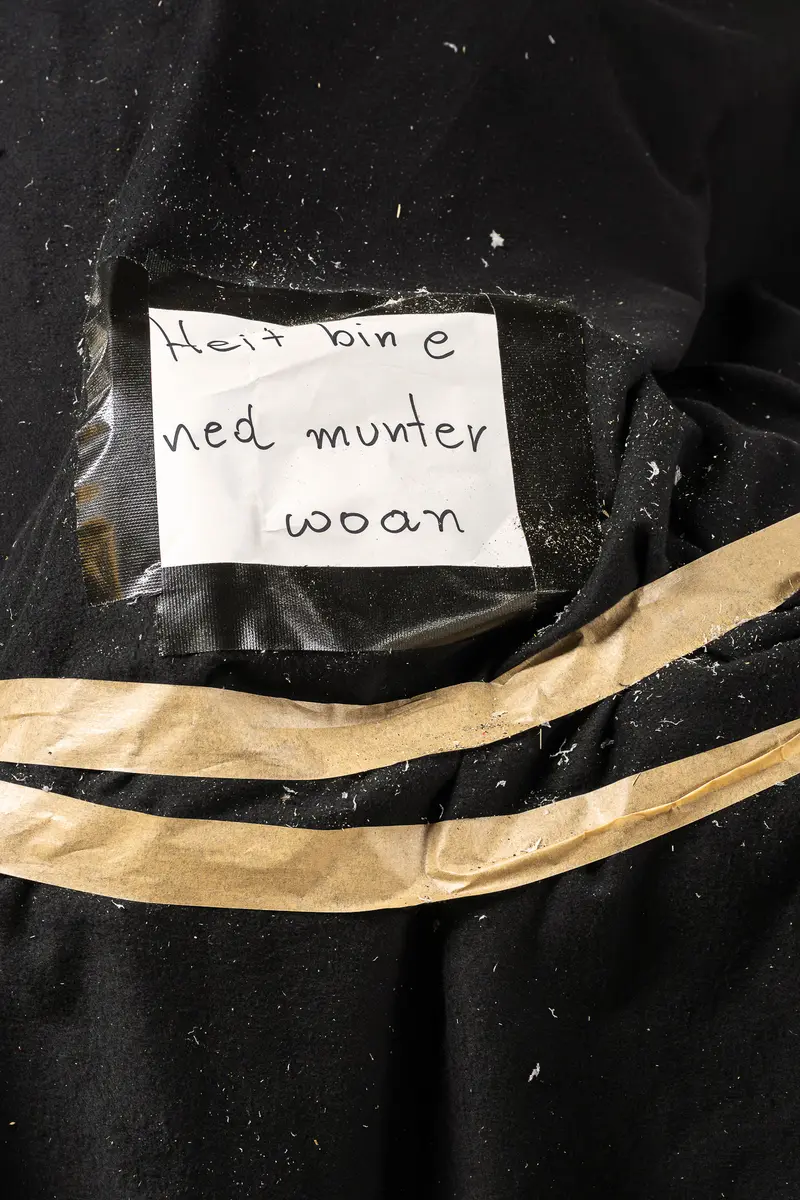 Handwritten Note on Black Fabric with Tape Fragment