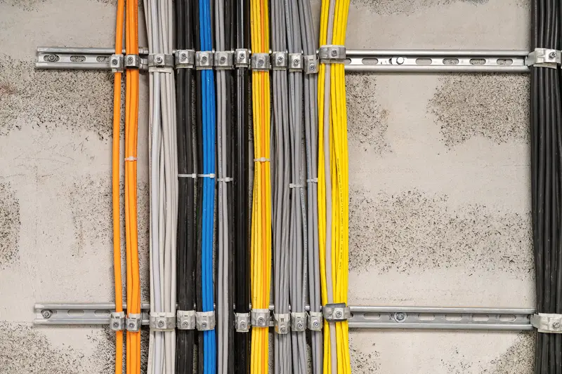 Colorful Electrical Cables Organized on Industrial Wall Mounting System