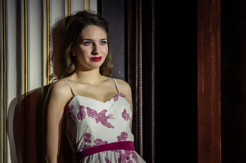 Elegant Woman in Floral Dress at Theatrical Photo Shoot