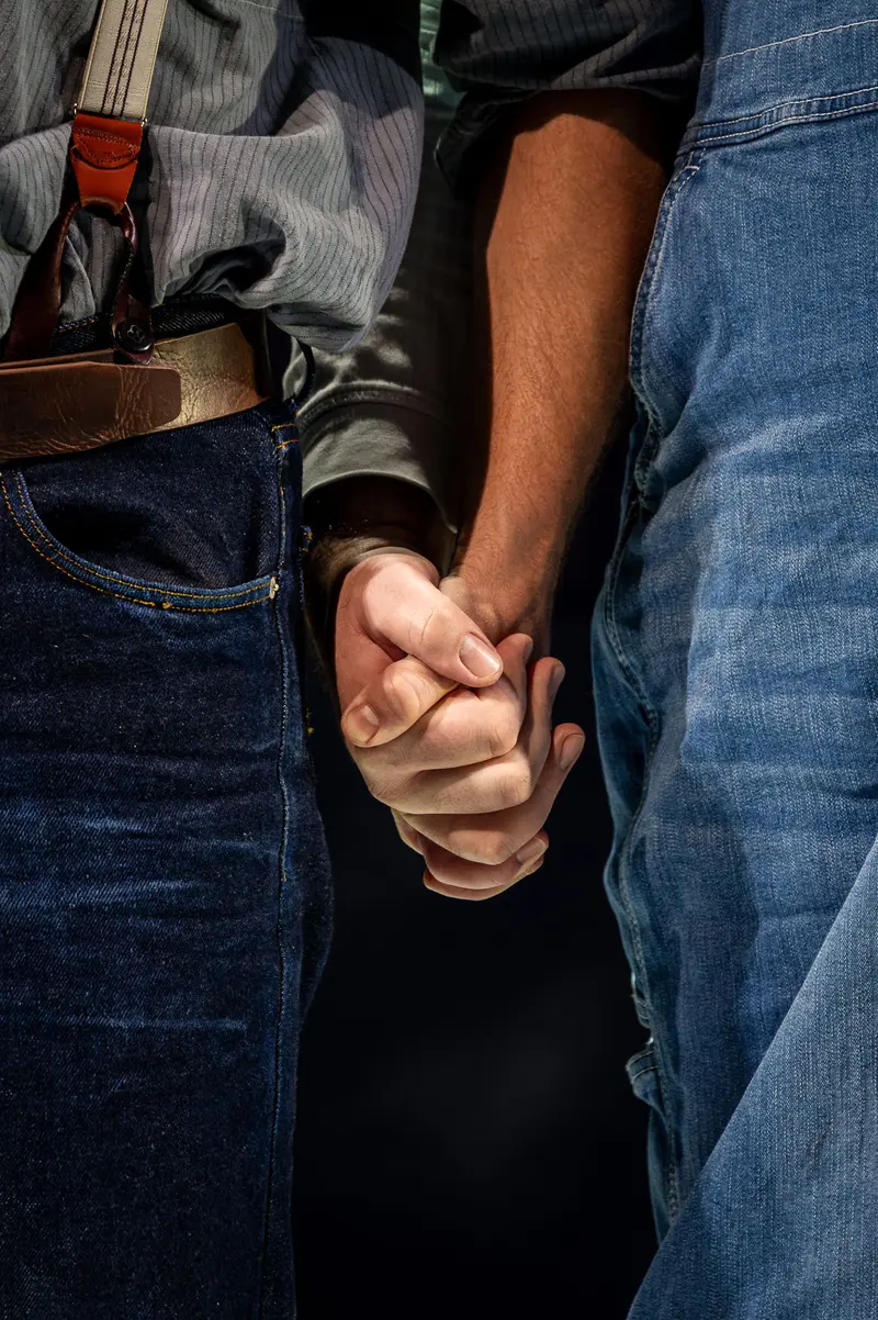 Intimate Hand-Holding Between Two People in Denim and Dark Clothing