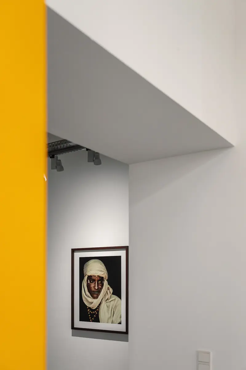 Abstract Gallery Interior with Framed Portrait and Vibrant Yellow Wall Panel
