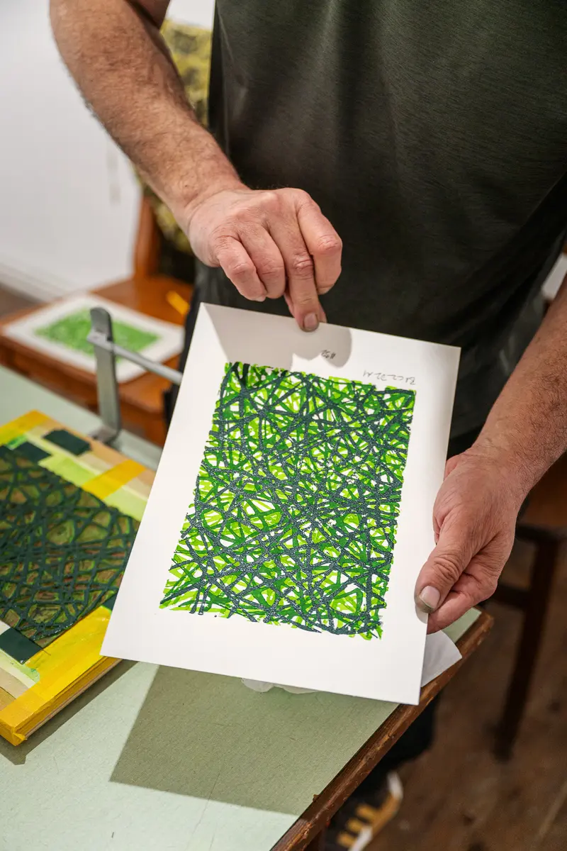 Detailed Green Geometric Print Held by Artist's Hands in Studio